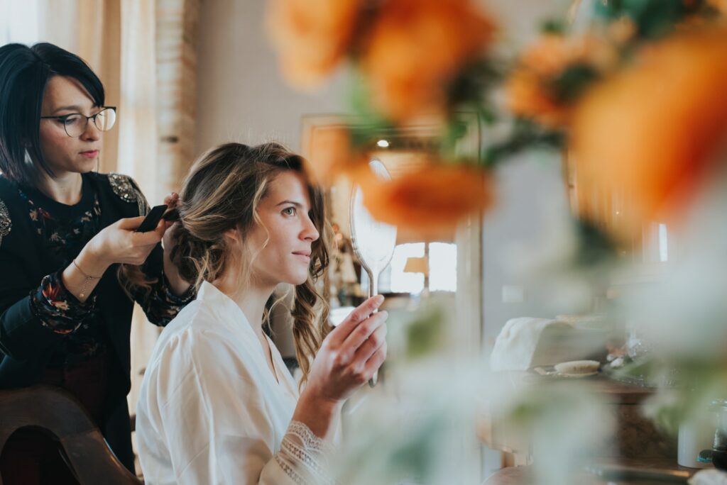 Bride preparing for wedding with hairstylist